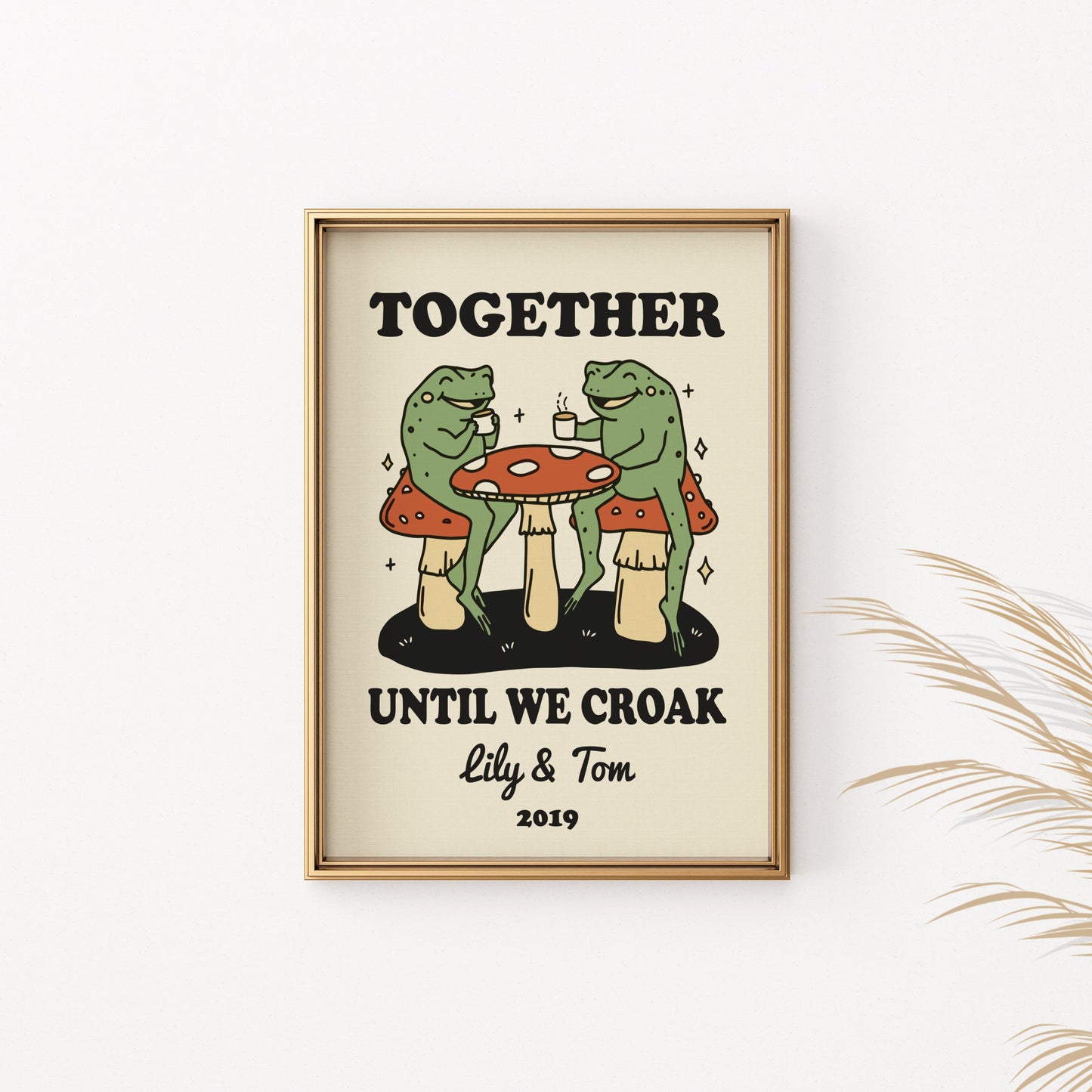 Framed print of two frogs drinking coffee on mushrooms, text reads "TOGETHER UNTIL WE CROAK Lily & Tom 2019".