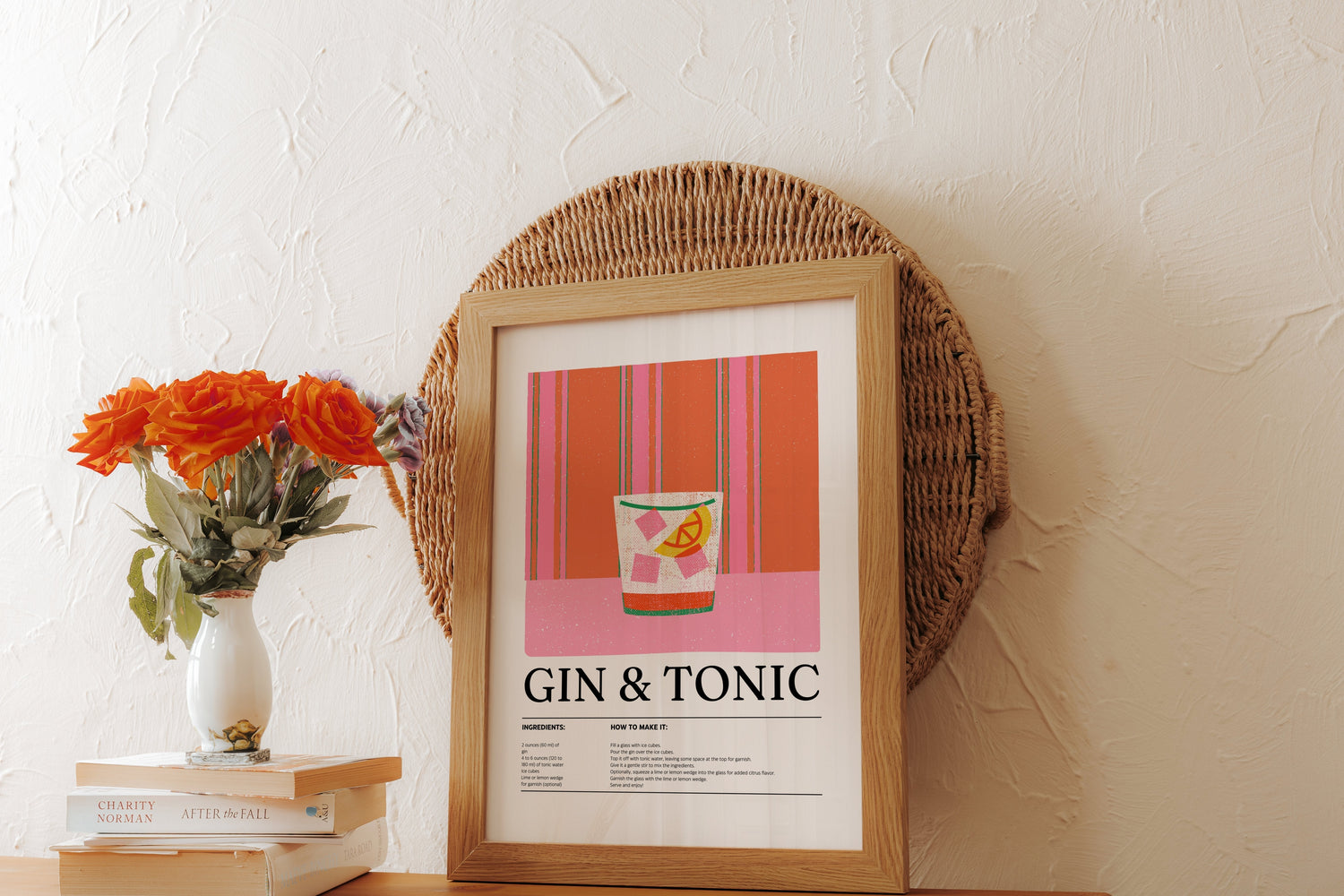 Stylish kitchen-bar decor with a framed 'Gin & Tonic' poster print, vibrant flowers in a vase, and stacked books on a wooden surface