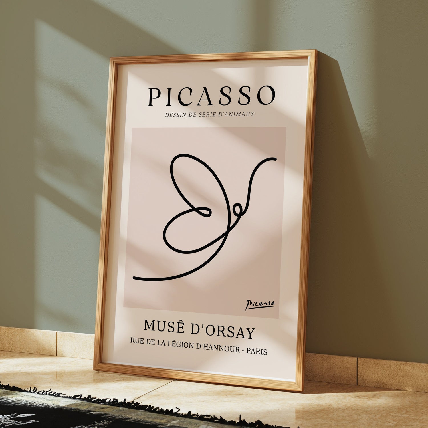 Framed Picasso art print poster featuring minimalist animal line drawing, displayed against a green wall.