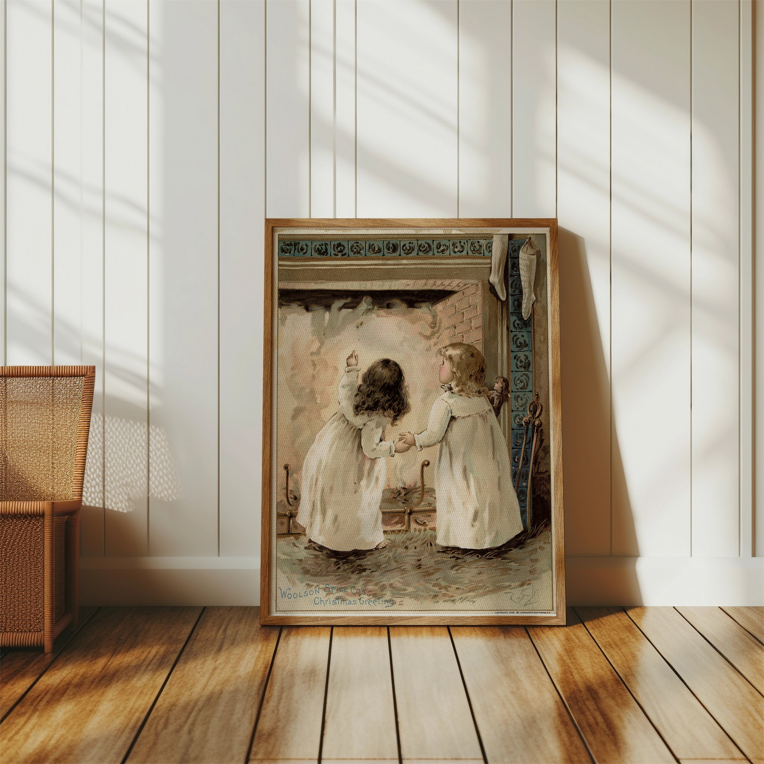 Framed vintage Christmas artwork poster of two children by a fireplace, displayed in a cozy, sunlit room.