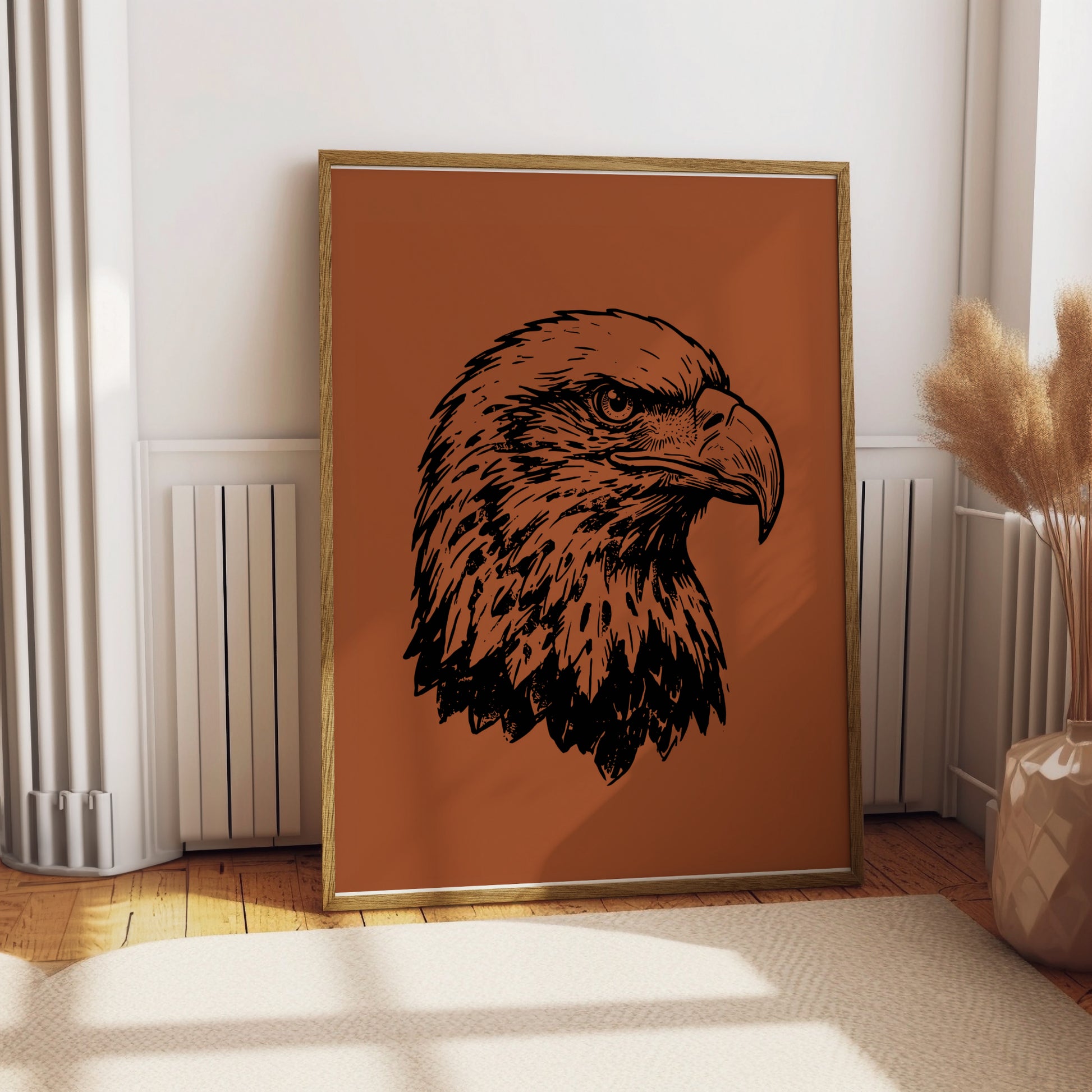 Black ink sketch of an eagle's head on a burnt orange background, framed.