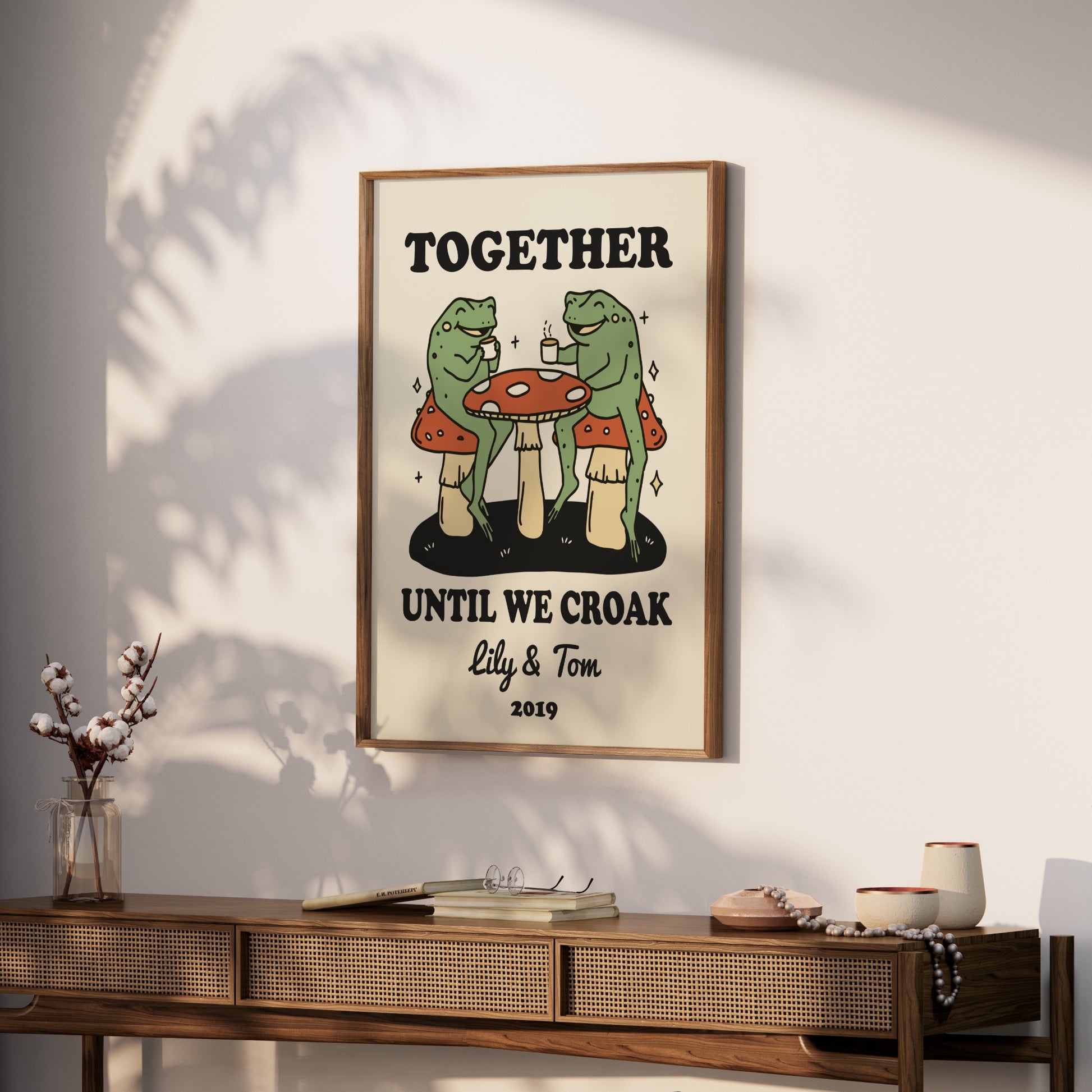Two frogs sit at a table with mushrooms, text "TOGETHER UNTIL WE CROAK lily & Tom 2019".