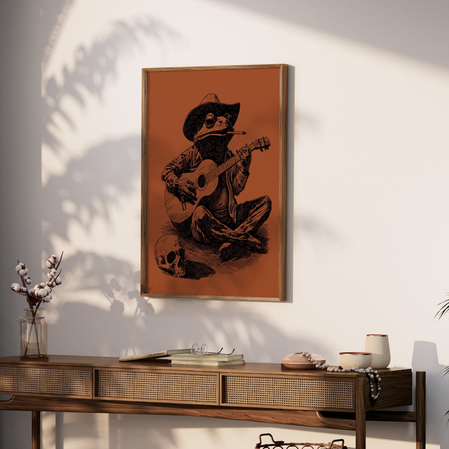 Framed artwork of a frog wearing a cowboy hat playing guitar with a skull.