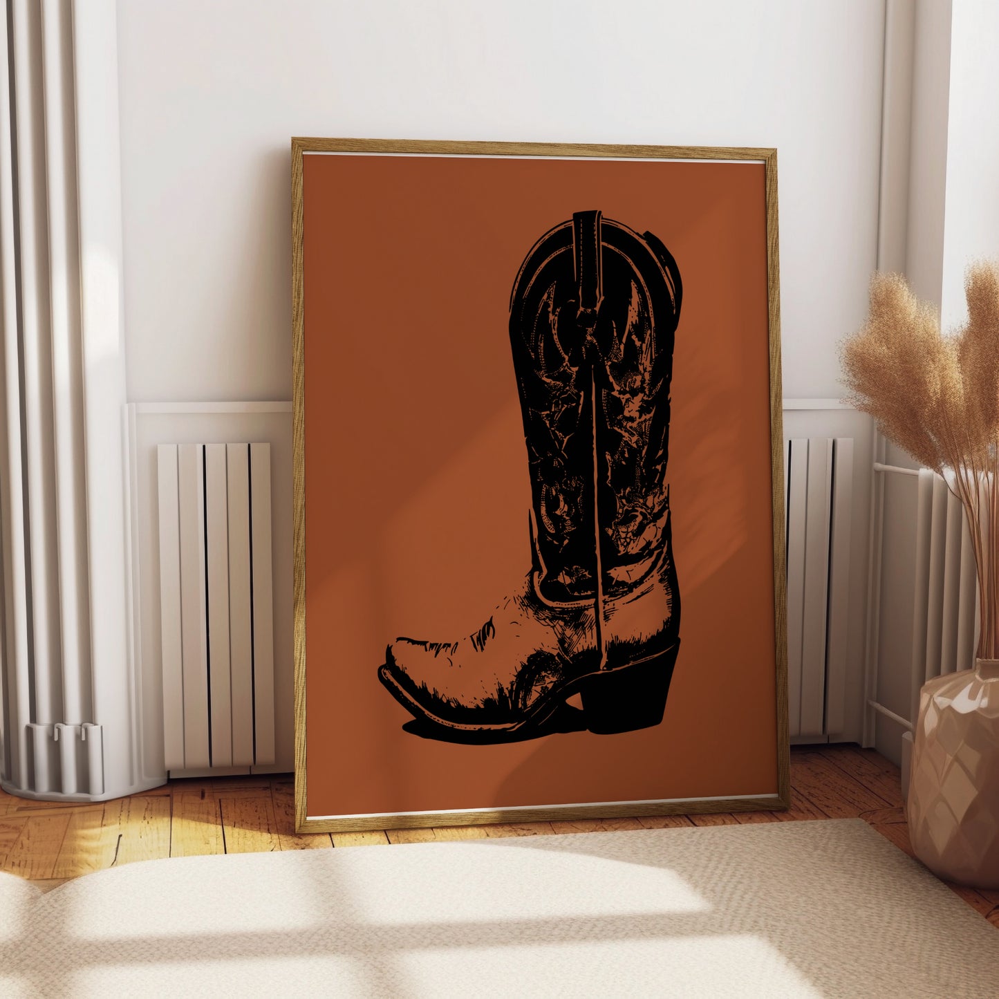 Black cowboy boot illustration on a burnt orange background in a wooden frame.