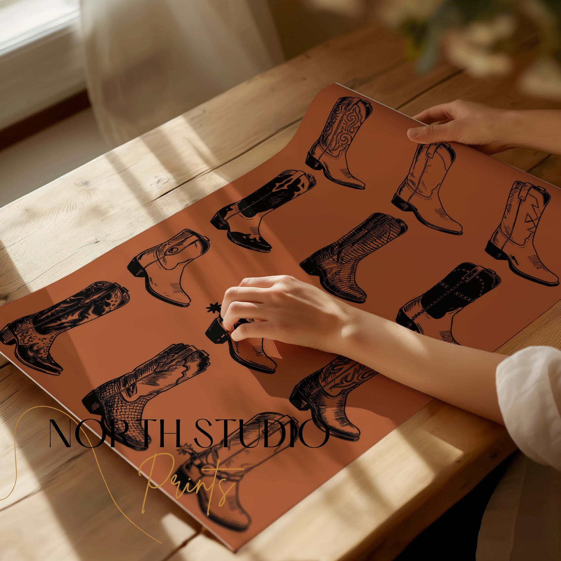 Brown paper featuring black line art of cowboy boots, with text "NORTH STUDIO Prints."