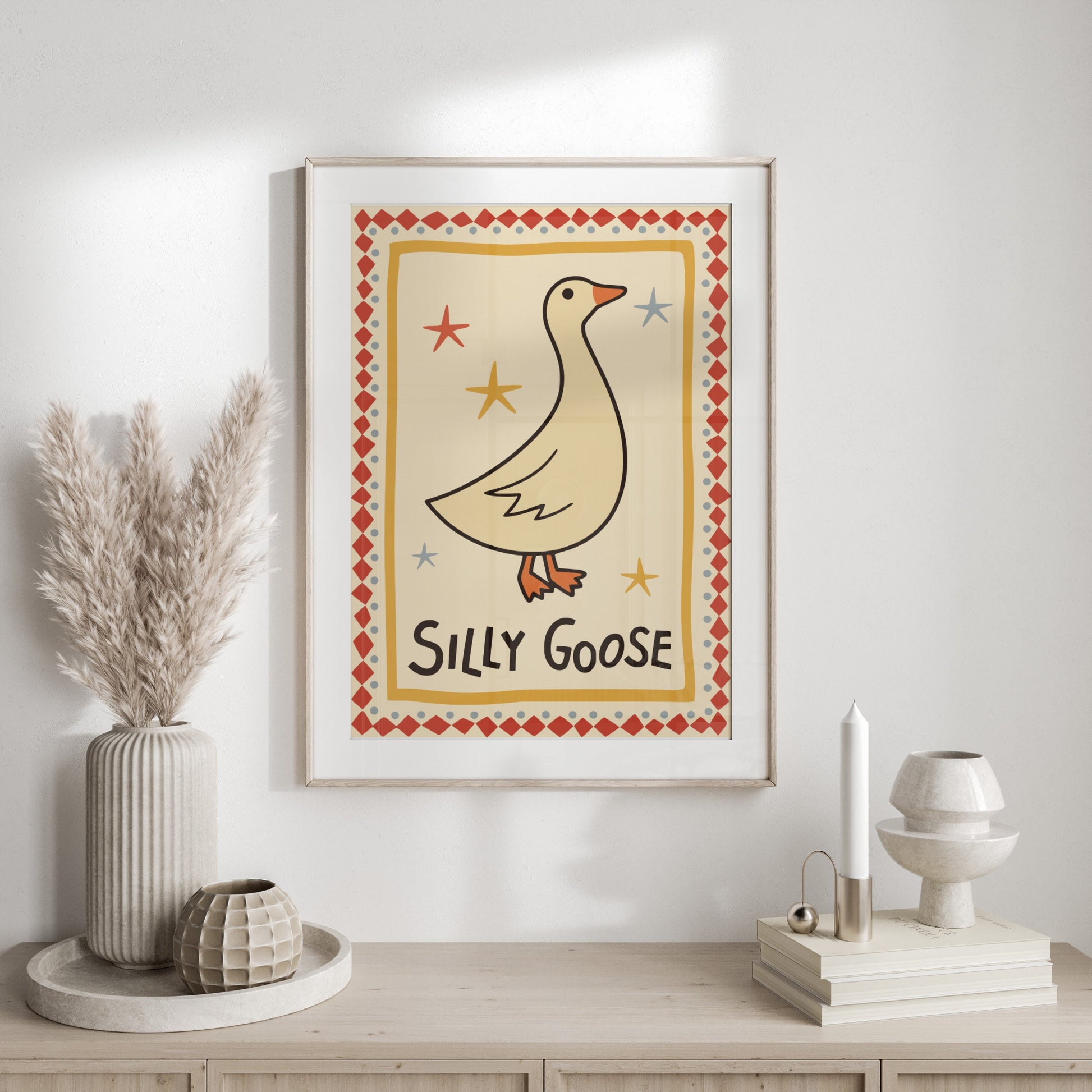 Framed artwork of a goose with "Silly Goose" text on a wall.