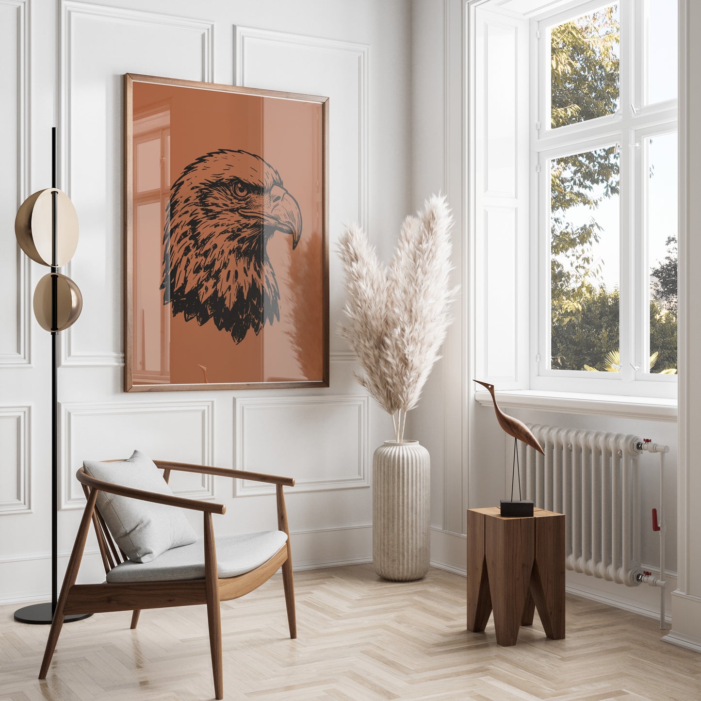 Framed artwork of eagle head on terracotta background above modern chair.