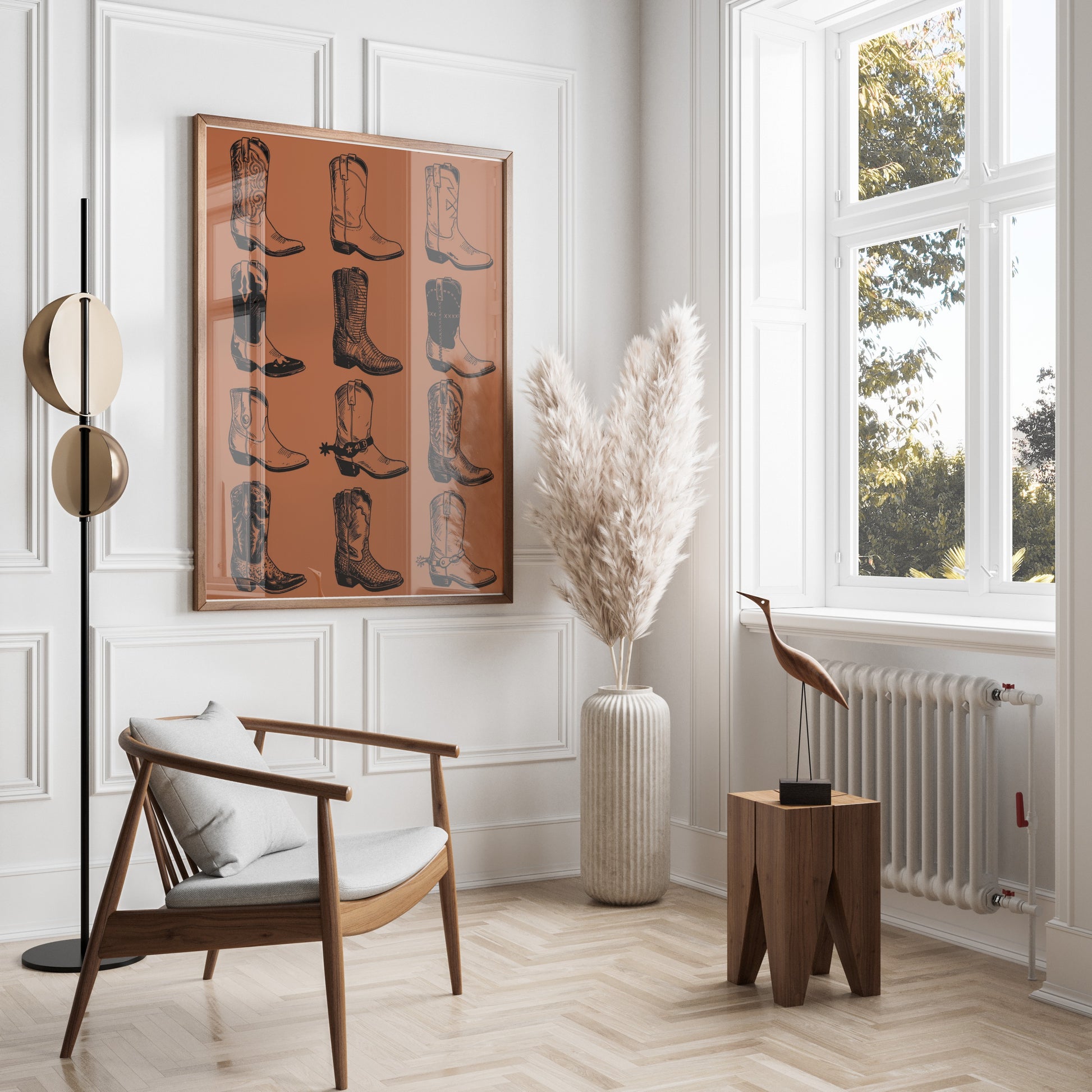 Framed print of cowboy boots, a wooden chair, and a floor lamp in a bright room.
