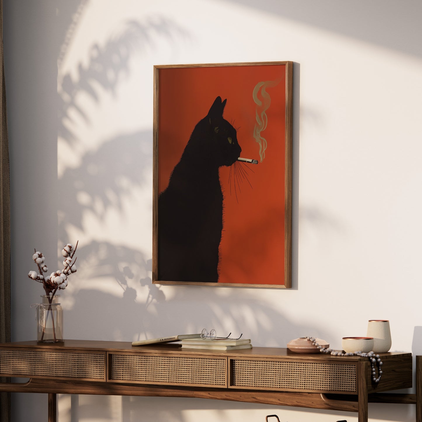 Black cat artwork on orange background, framed, hanging above a wooden console table.