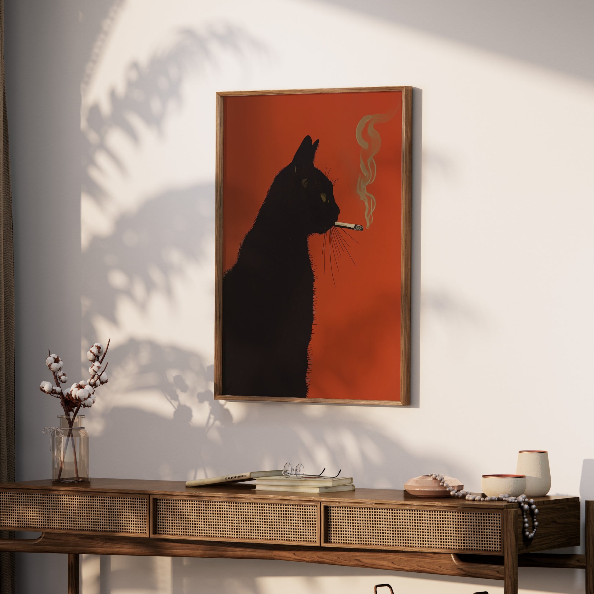 Black cat artwork on orange background, framed, hanging above a wooden console table.
