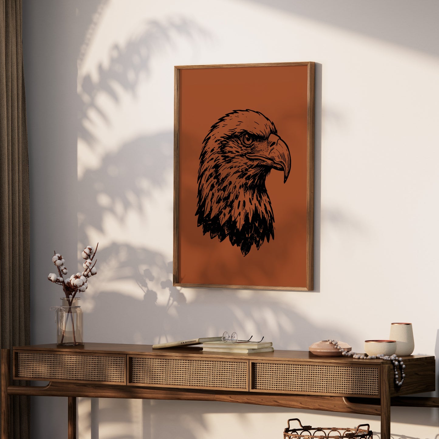 Line drawing of an eagle head on a burnt orange background, framed and hung on a wall.