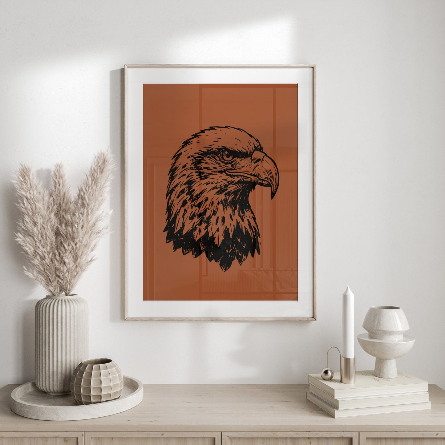 Black and white sketch of an eagle's head in a framed print on a wall.