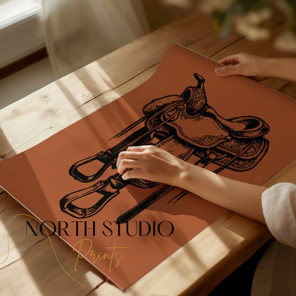 Western saddle illustration on copper paper, hands holding edge, "North Studio Prints" logo.
