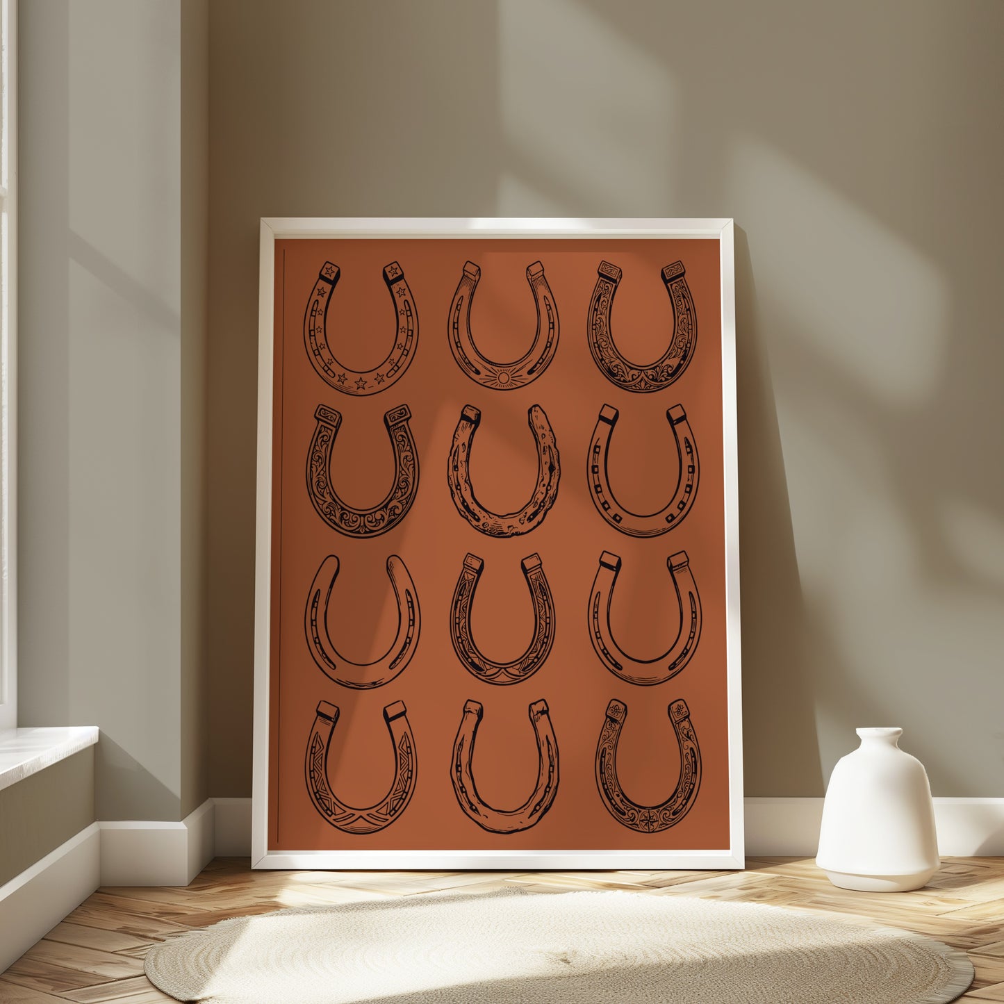 Framed artwork with a pattern of twelve black horseshoe illustrations on an orange background.