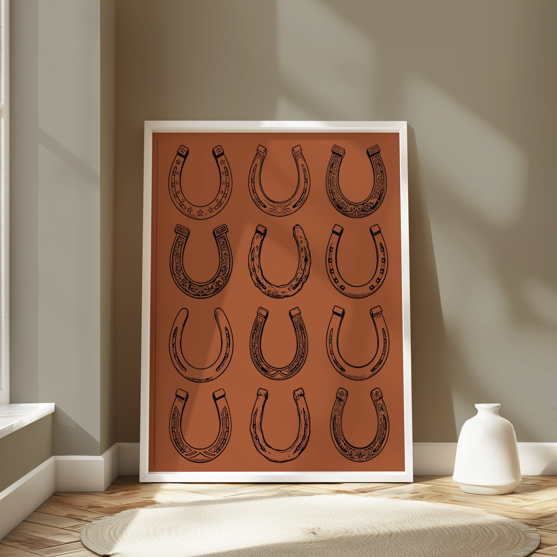 Framed artwork with a pattern of twelve black horseshoe illustrations on an orange background.