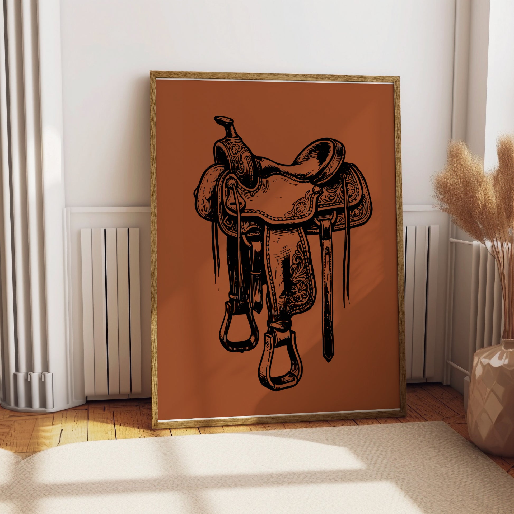 Framed digital art print of a detailed black and white saddle on a burnt orange background.