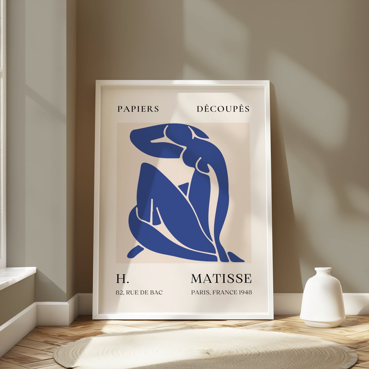 Framed Abstract Blue Figure Henri Matisse art poster leaning against a beige wall in a sunlit room, ideal for modern room decor.
