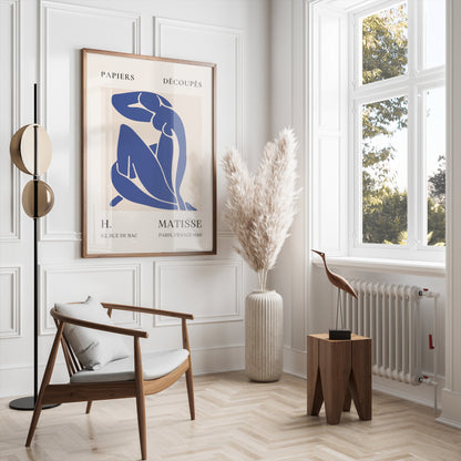 Abstract Blue Figure Henri Matisse art poster in a wooden frame, styled in a modern living room with neutral tones and elegant furniture.