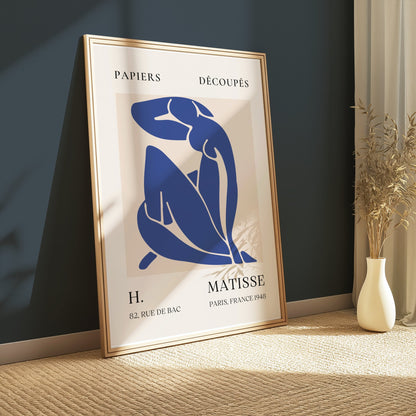 Abstract Blue Figure Henri Matisse art poster in a gold frame, leaning against a dark green wall with soft lighting, perfect for modern interiors.