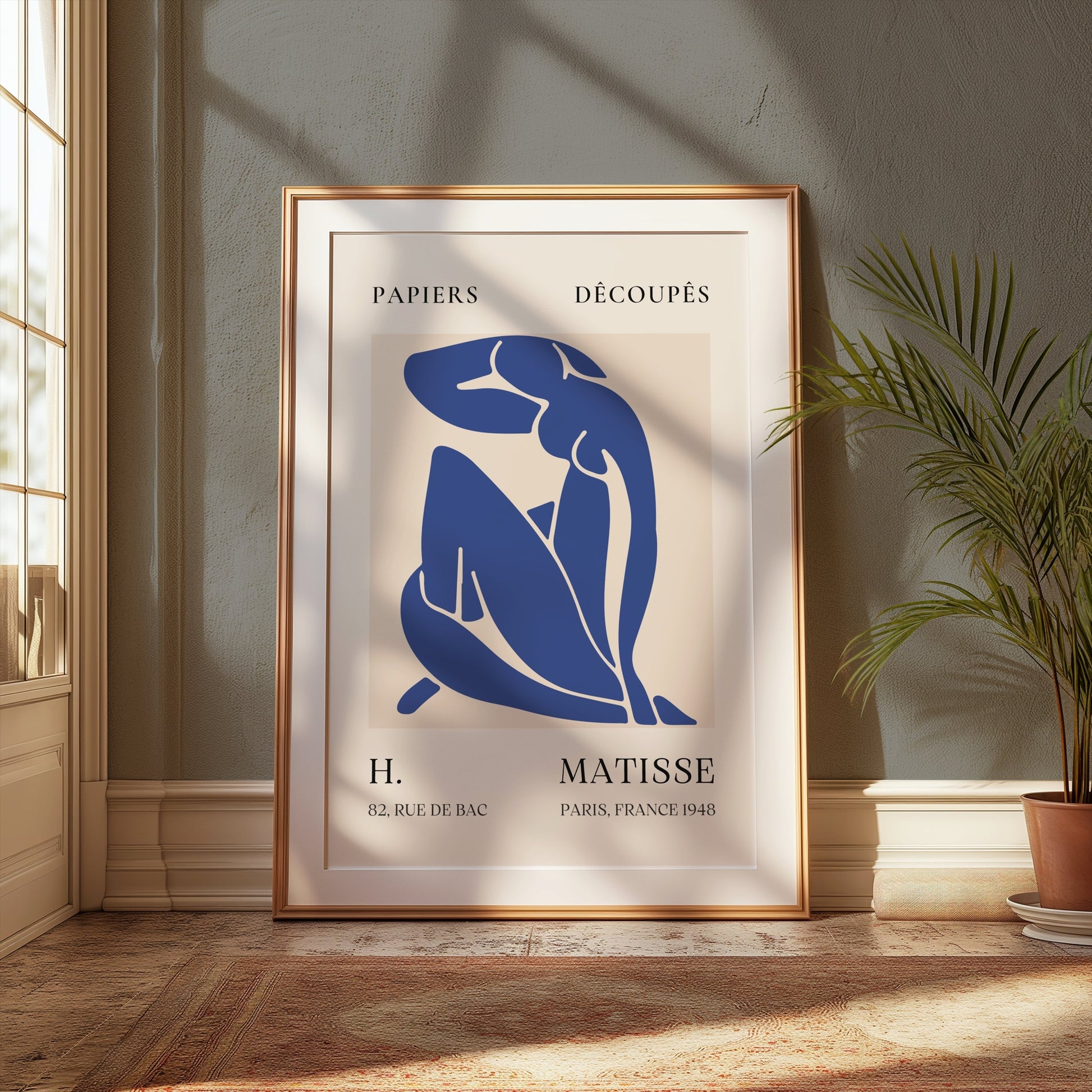 Abstract Blue Figure Henri Matisse art poster in a gold frame, styled in a classic interior with a plant and natural lighting, enhancing room decor.