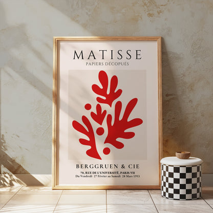 Matisse Papiers Découpés poster in a gold frame featuring red abstract cutouts, styled on a textured wall with decorative accents in a modern interior.