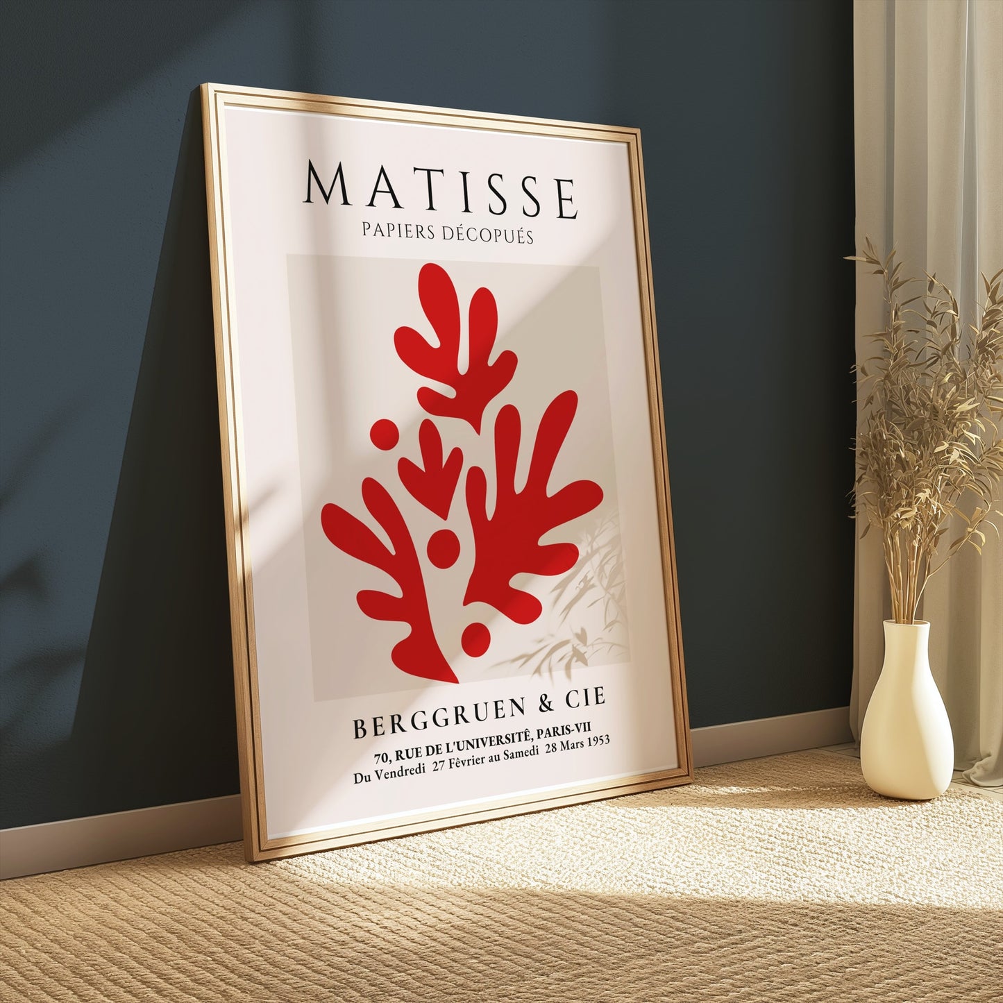 Framed Matisse Papiers Découpés poster with red abstract cutouts, leaning against a dark green wall, styled with neutral decor in a cozy setting.