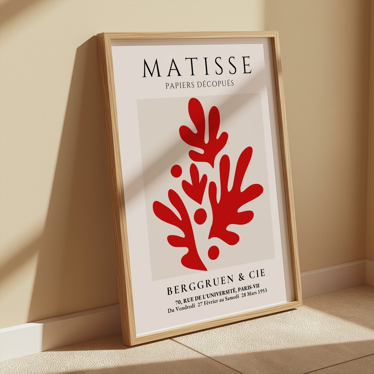 Matisse Papiers Découpés poster with red abstract design, framed and leaning against a beige wall, styled with soft natural light in a minimalist space.