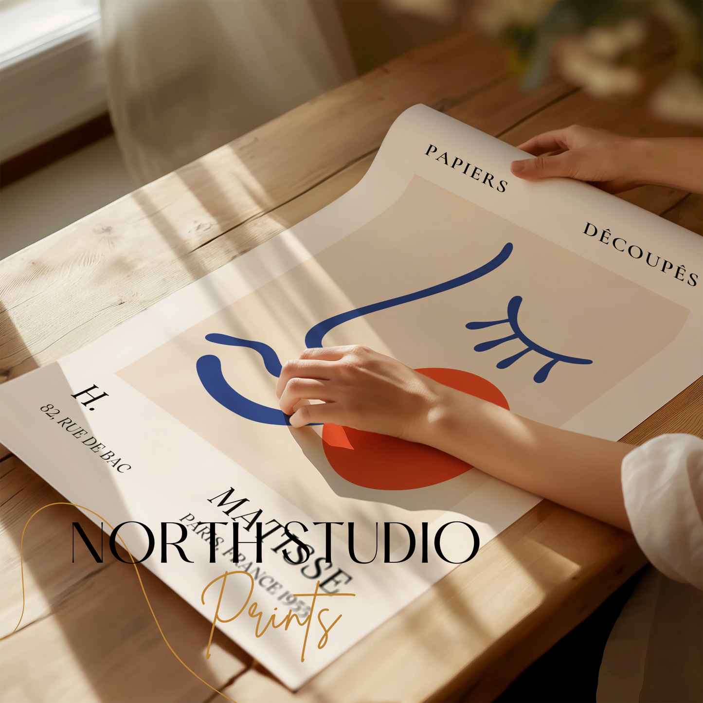 Artistic Matisse Papercut Face Design Wall Art Poster being unrolled on a wooden table, highlighting its vibrant abstract design and premium quality.