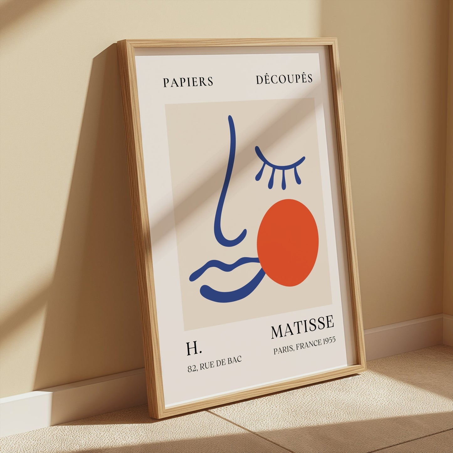 Framed Artistic Matisse Papercut Face Design Wall Art Poster leaning against a wall in a sunlit room, showcasing modern minimalistic home decor.