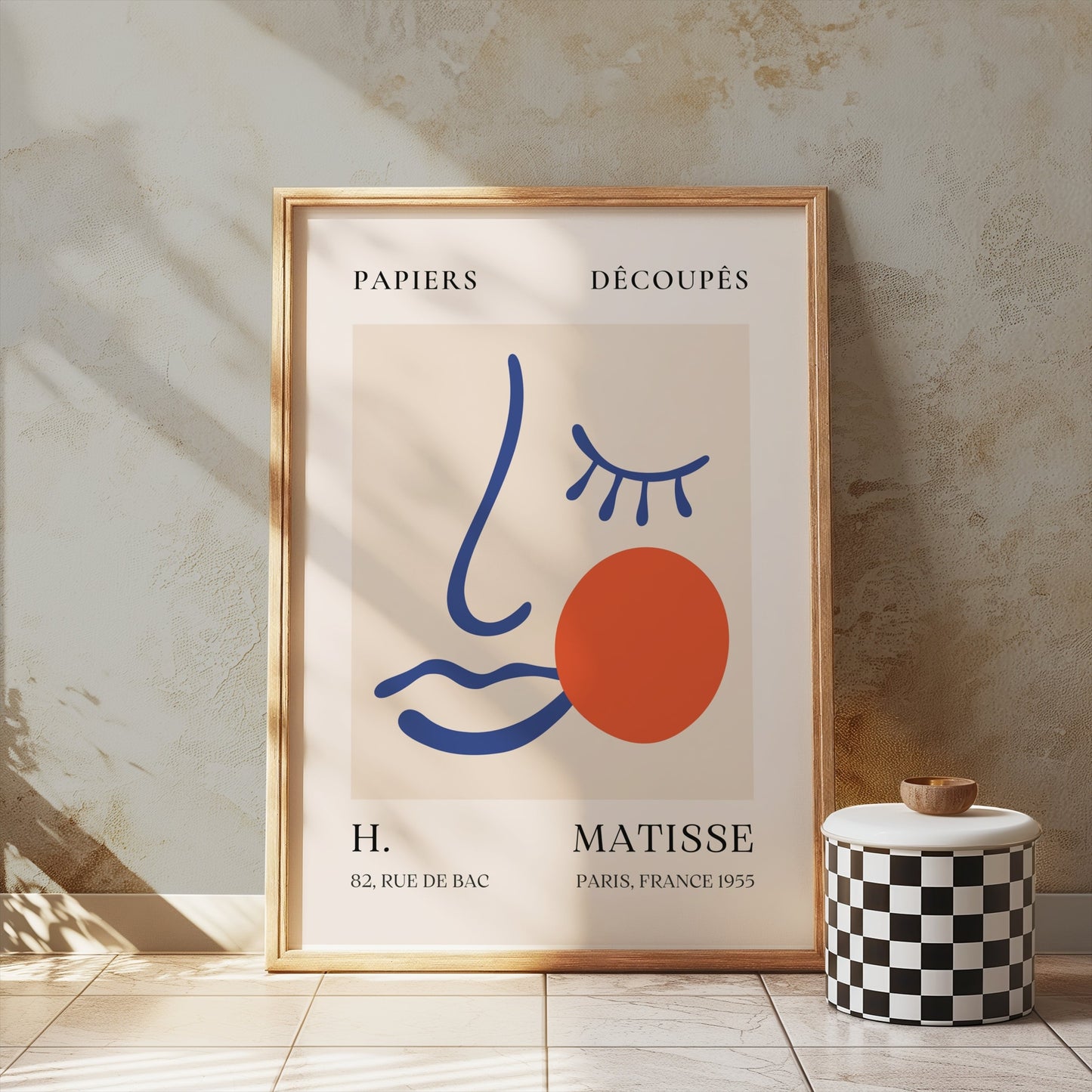 Artistic Matisse Papercut Face Design Wall Art Poster in a wooden frame, styled in a rustic setting with natural light and decorative accents.