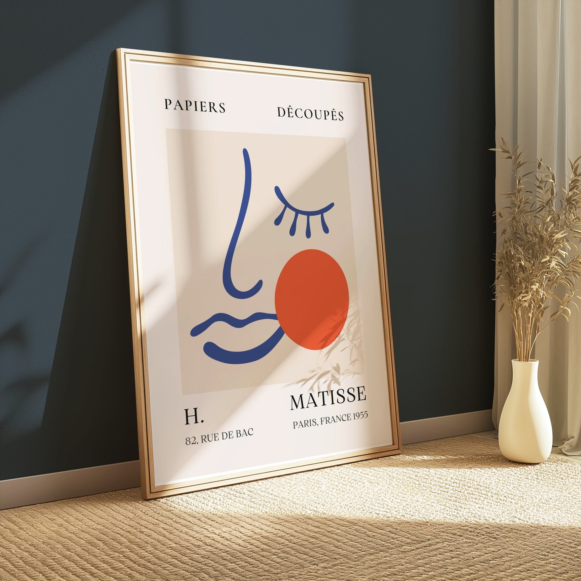 Artistic Matisse Papercut Face Design Wall Art Poster in a wooden frame, leaning against a dark green wall with soft natural light and minimalist decor.