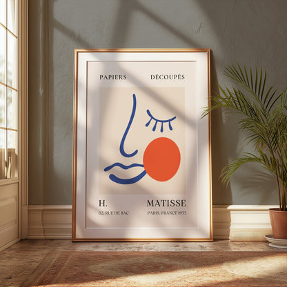 Artistic Matisse Papercut Face Design Wall Art Poster in a gold frame, styled in a classic room with green walls, natural light, and a potted plant.