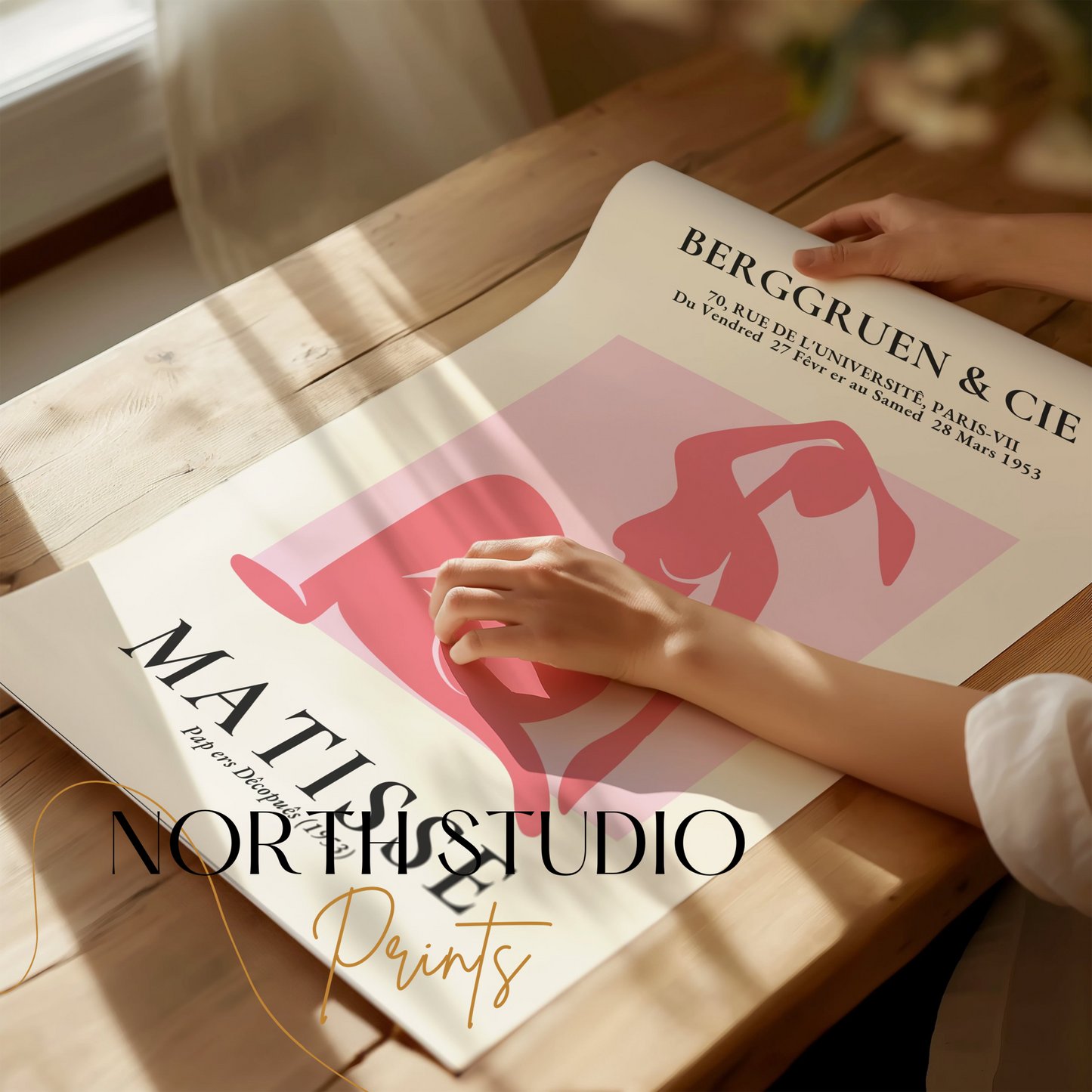 Close-up of BERGGRUEN & CIE Matisse exhibition vintage poster being unrolled on a wooden table, showcasing its pink silhouette cut-out design.