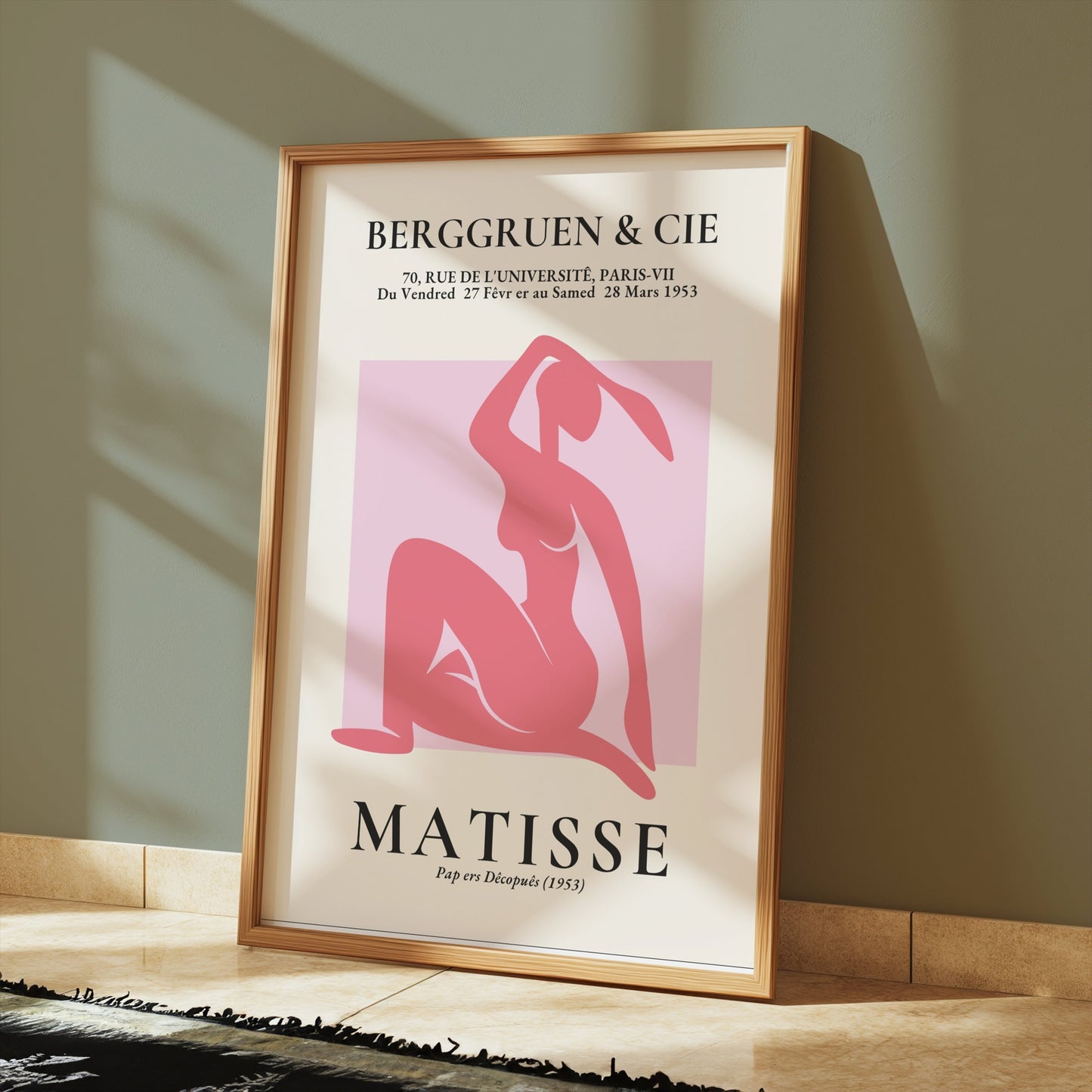 Framed BERGGRUEN & CIE Matisse exhibition vintage poster with a pink silhouette cut-out, leaning against a green wall on a wooden floor.