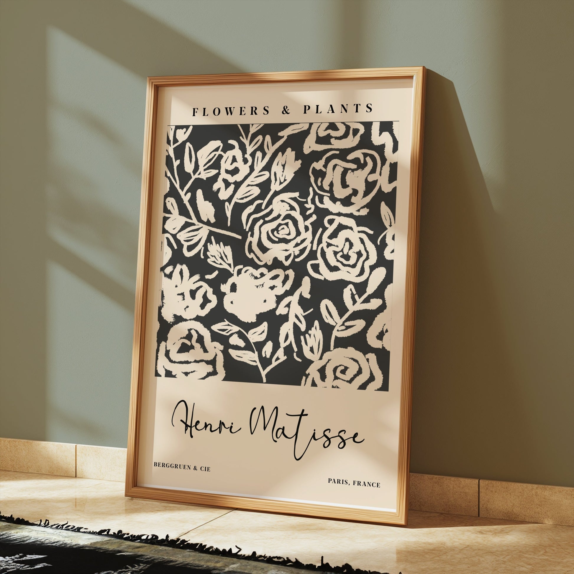 Henri Matisse floral art print leaning against a green wall on a tiled floor, showcasing abstract black and white botanical design.