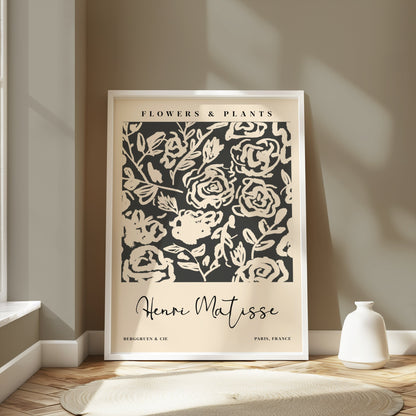 Henri Matisse floral art print in a white frame, placed in a bright room with neutral decor, featuring abstract black and white flowers.