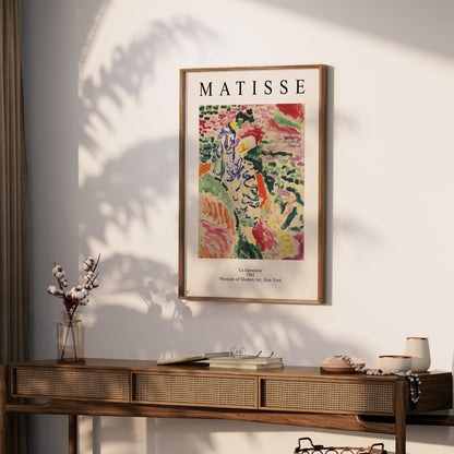 Framed Matisse La Japonaise poster displayed on a wooden console table in a bright, modern interior. Ideal for art-inspired home decor.