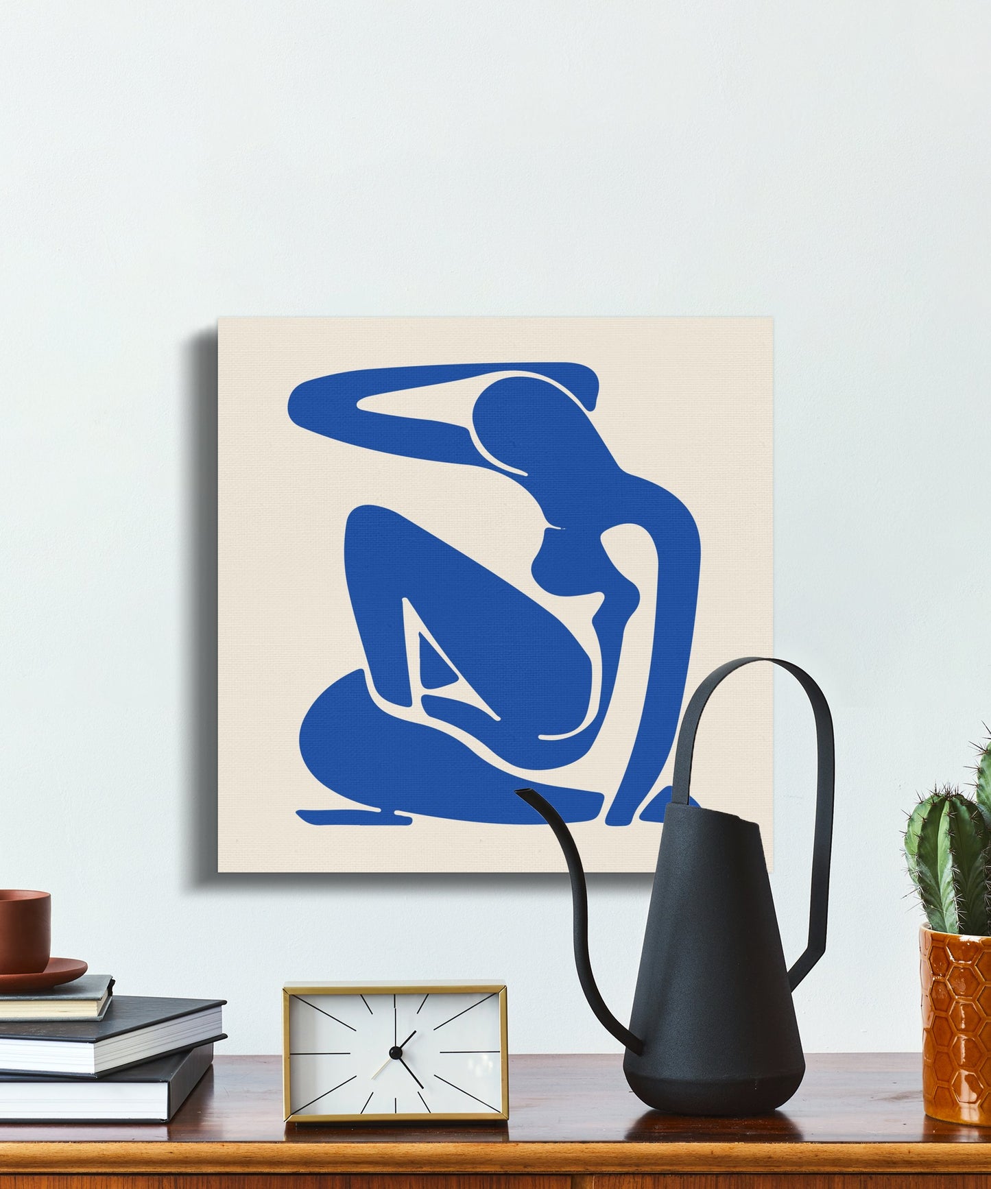 Henri Matisse inspired minimalism canvas wrap styled on a wooden console with modern decor elements like a watering can and small plants.