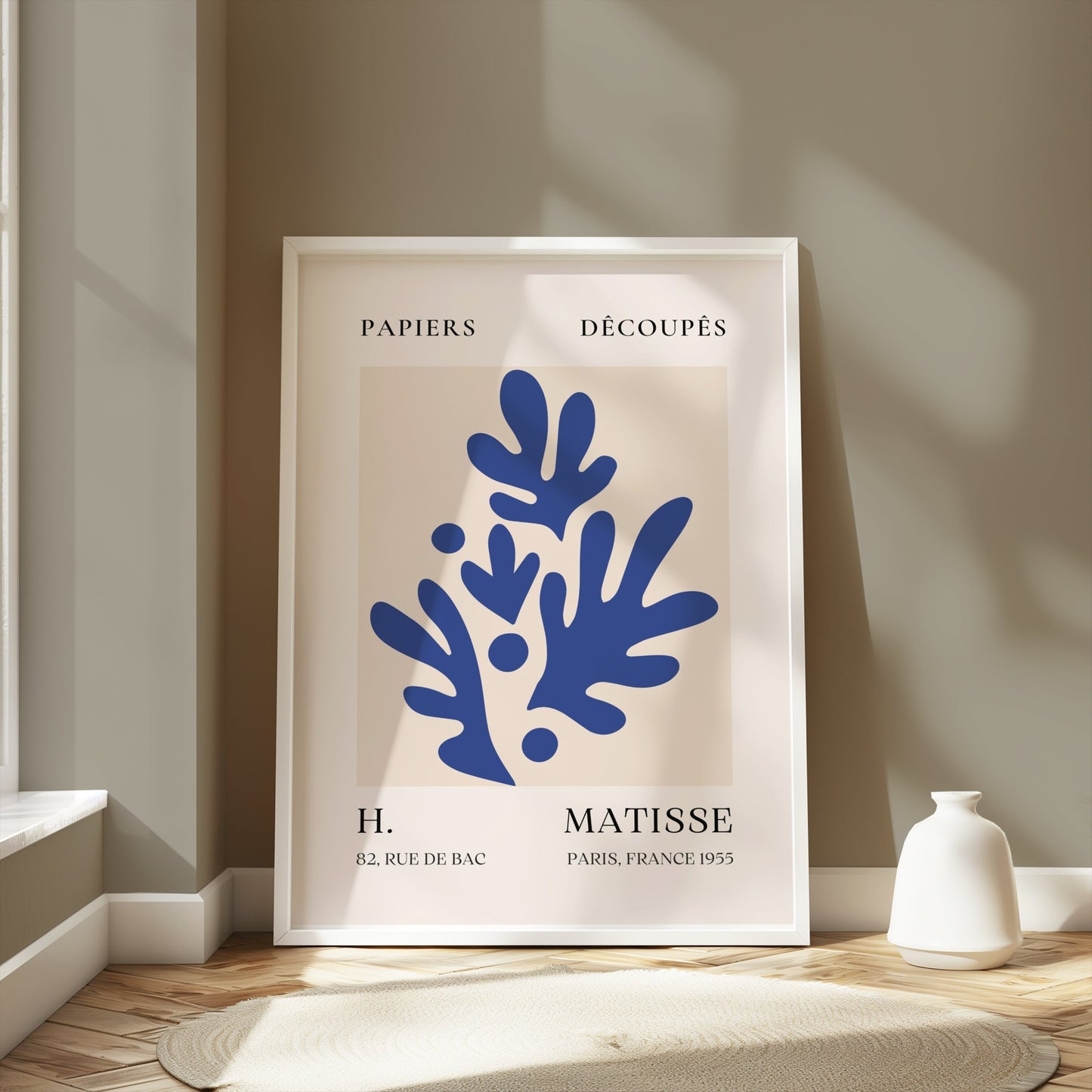 Elegant Matisse-inspired poster featuring blue leaf cut-outs, framed and styled in a neutral-toned room with natural light.