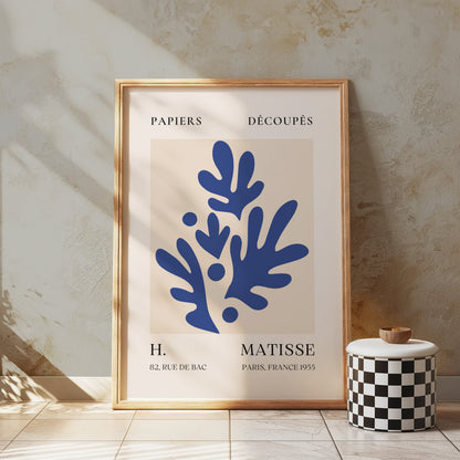 Matisse-style Parisian art print with blue botanical design, framed and displayed in a rustic setting with textured walls and natural light.