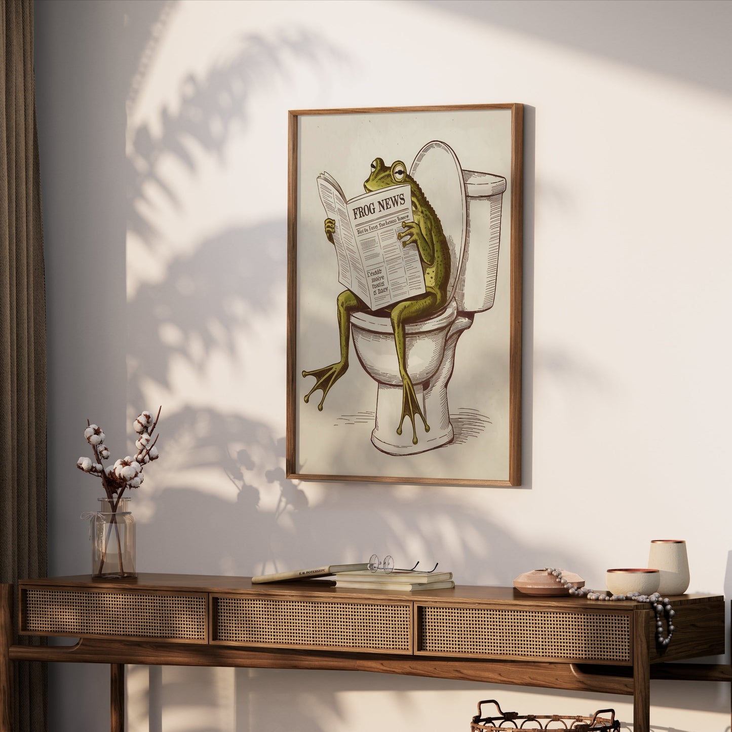 Frog reading newspaper on toilet poster framed and hung above a wooden console table, creating a playful and unique decor piece.