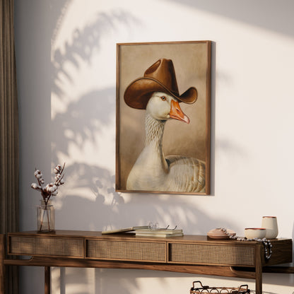 Goose wearing cowboy hat art print mounted on a wall above a wooden console table, adding a touch of humor and charm to the space.