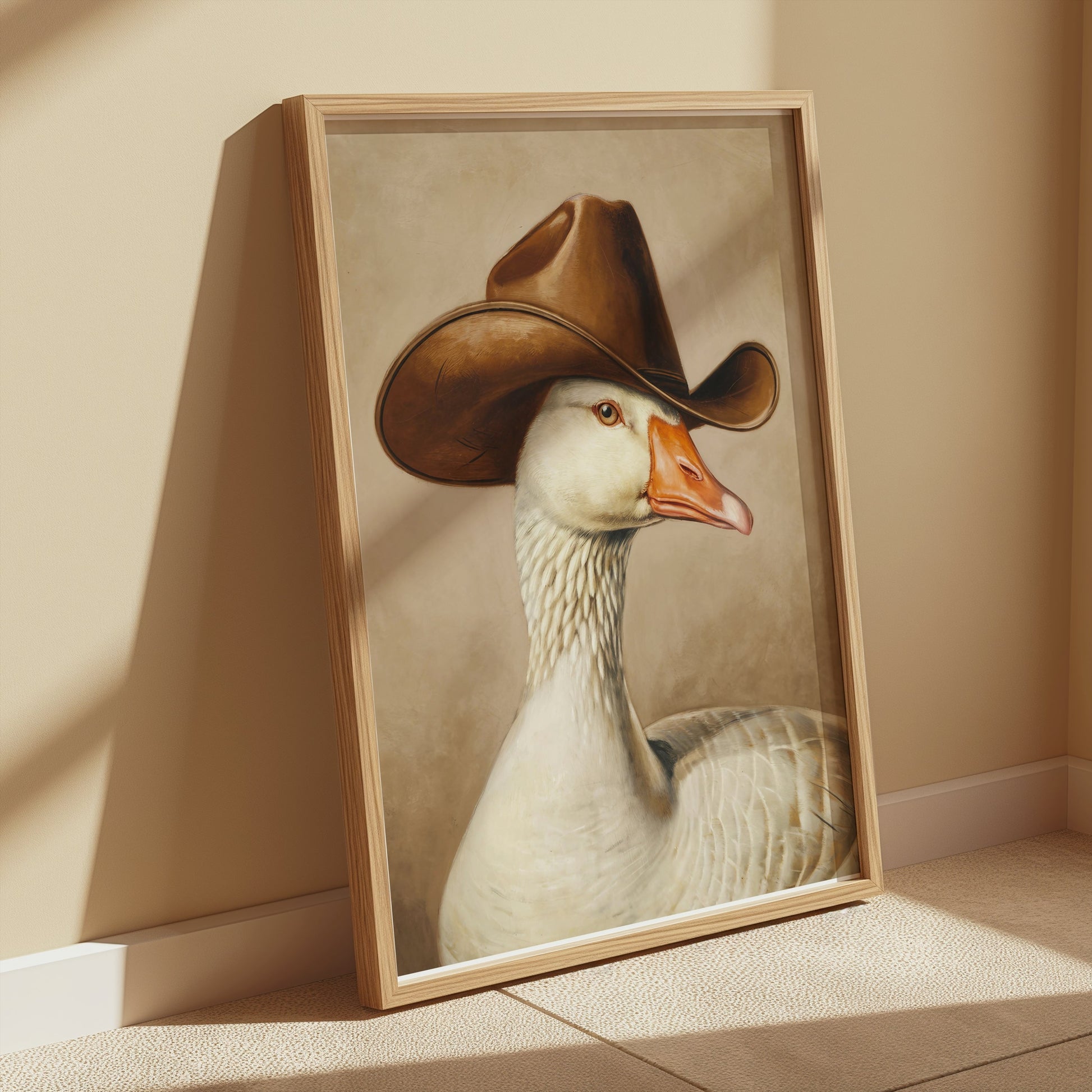 Goose wearing cowboy hat art print leaning against a beige wall, bathed in natural light, perfect for farmhouse or novelty decor themes.