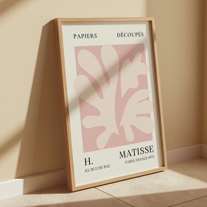Henri Matisse inspired Papiers Decoupes art print poster in a wooden frame, placed on a light-colored floor with soft sunlight and shadows.