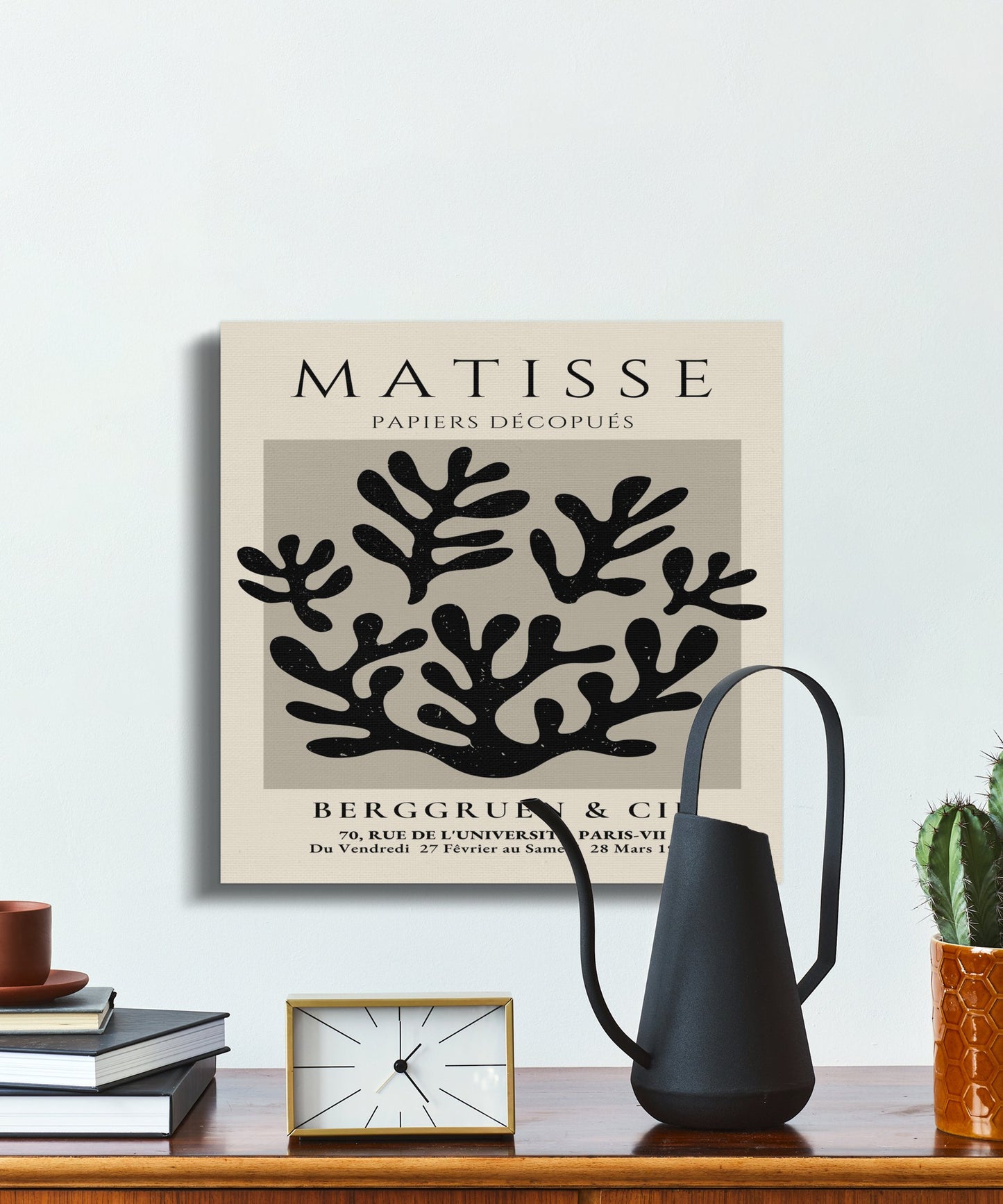 Elegant Henri Matisse inspired wall art with coral design, displayed above a shelf with modern decor items and a black watering can.