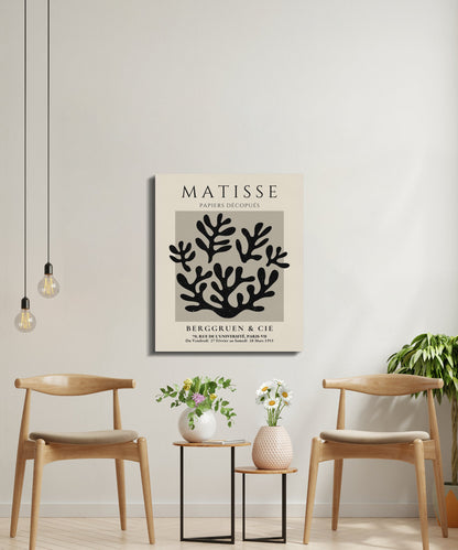 Henri Matisse inspired canvas wall art with black coral design, styled in a minimalist seating area with wooden chairs and plants.