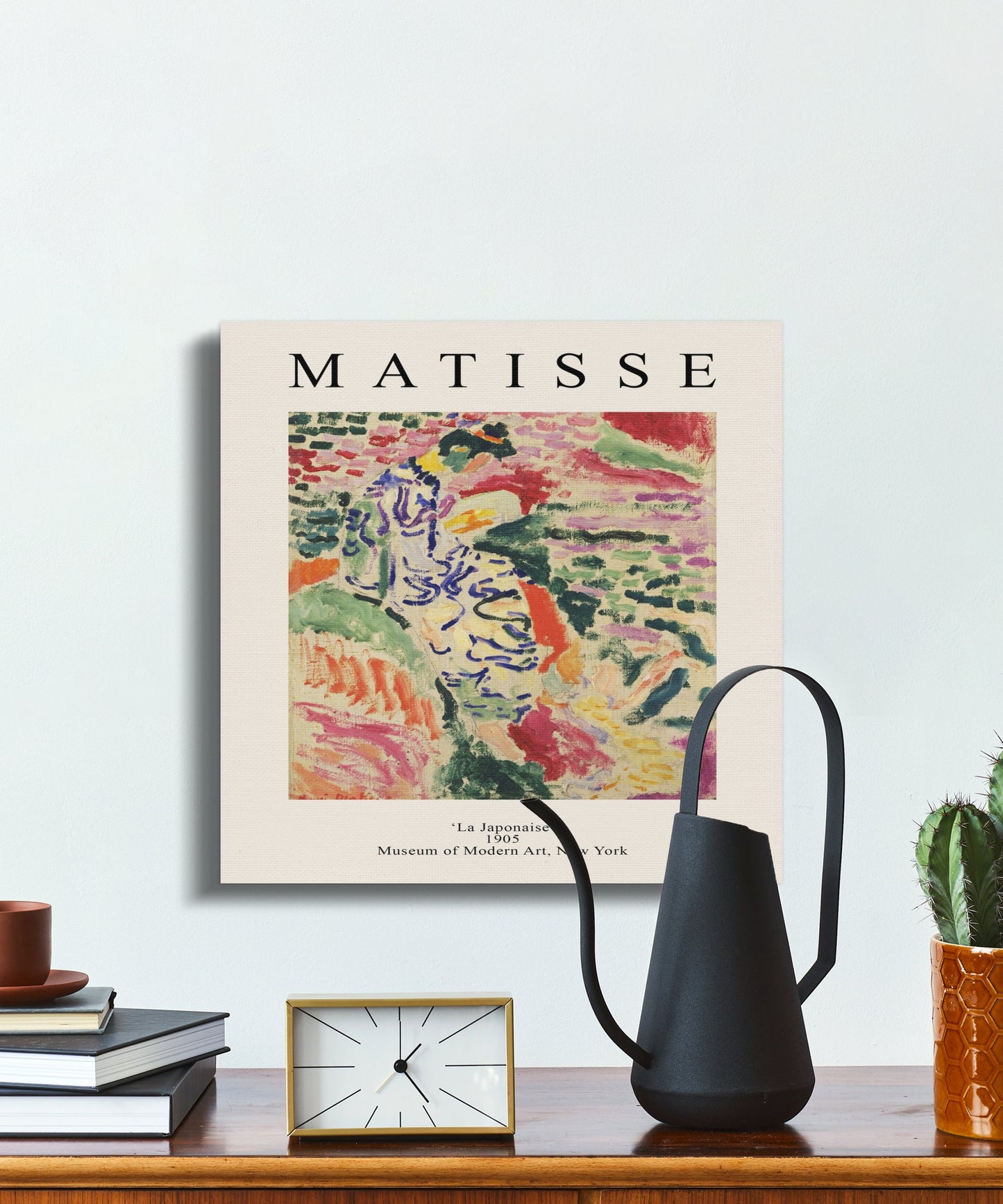 Henri Matisse La Japonaise canvas on a desk with a watering can, clock, and books, adding a fine art touch to interiors.
