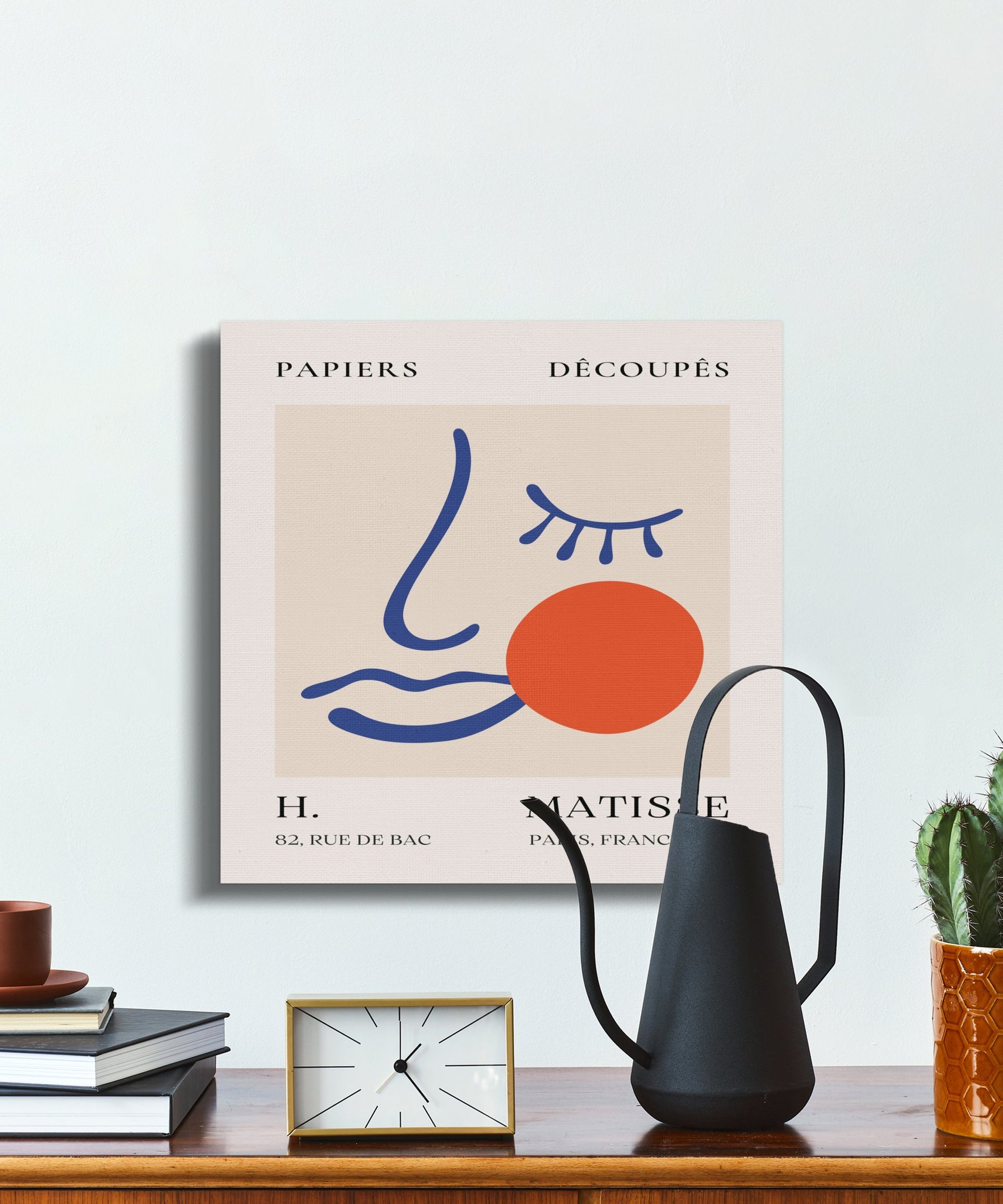 Henri Matisse Papiers Decoupes canvas wrap on a wall near a black watering can and decor, blending fine art with contemporary home styling.