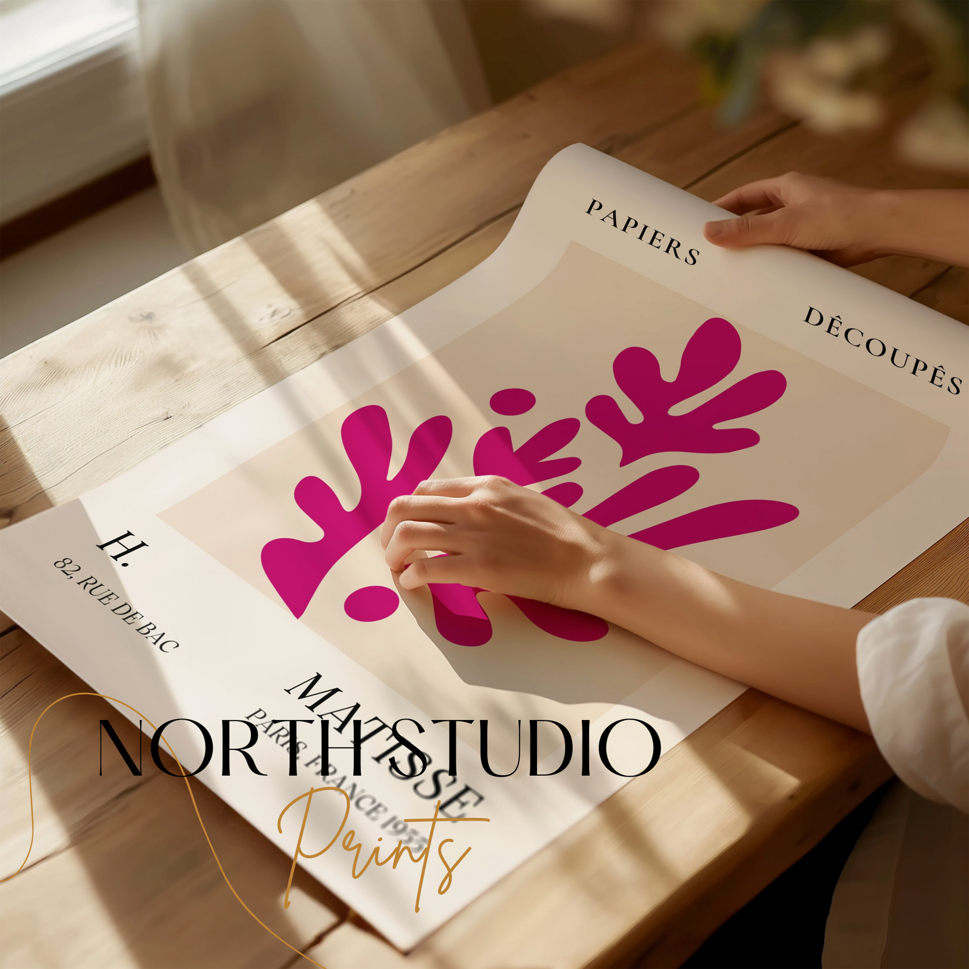 Henri Matisse Paris France 1955 Papiers Découpés poster being unrolled on a wooden table, showcasing its vibrant magenta cut-out design.