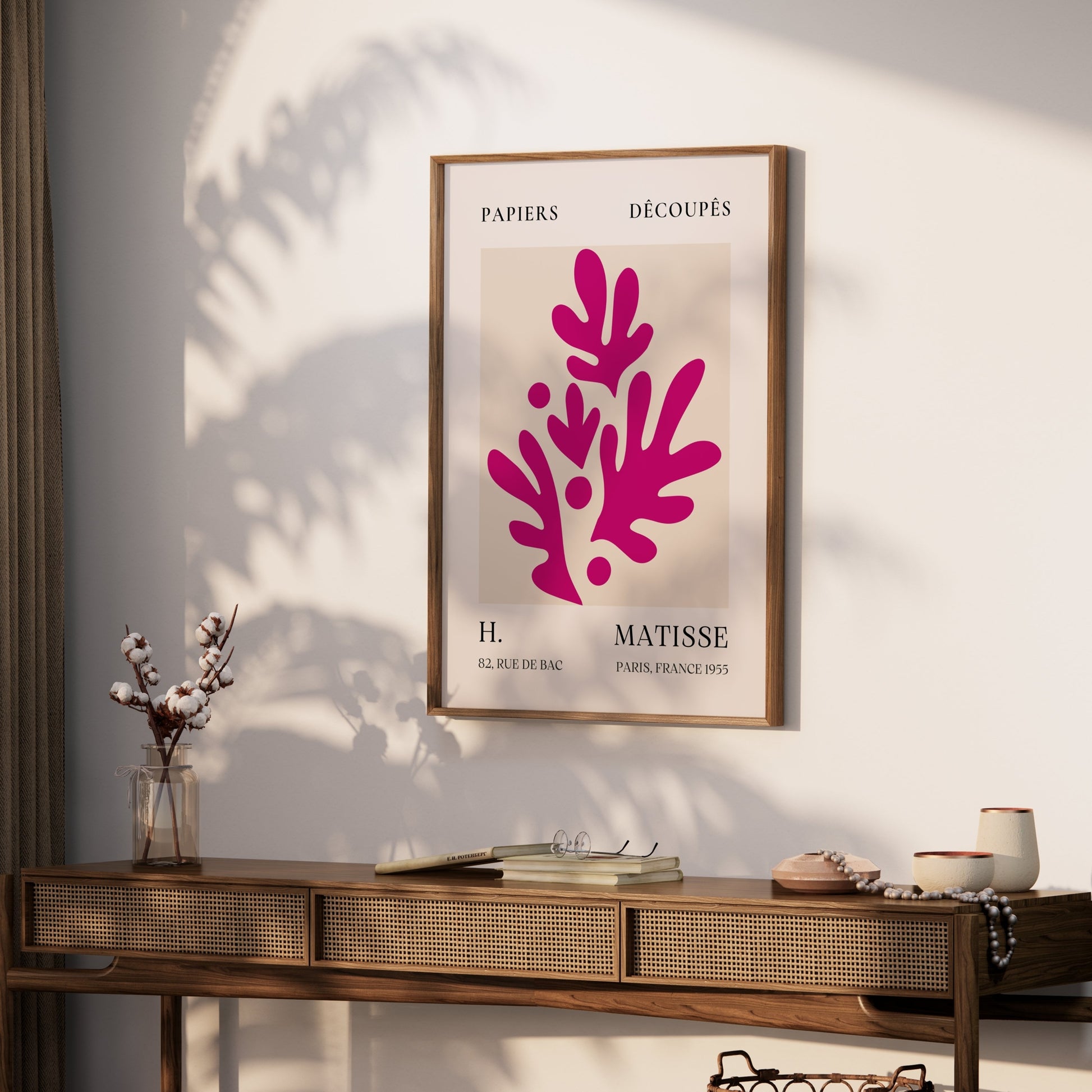 Framed Henri Matisse Paris France 1955 Papiers Découpés poster displayed on a wooden console in a modern living room with natural decor.